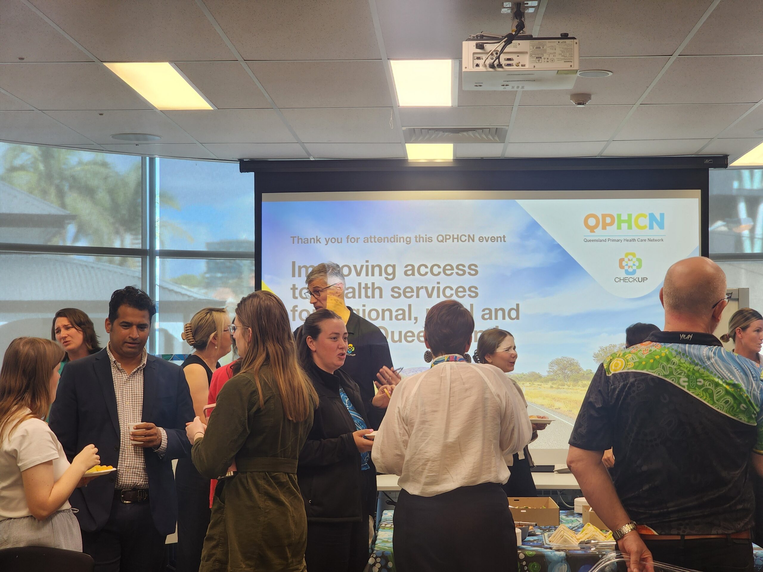Attendees networking at the QPHCN event